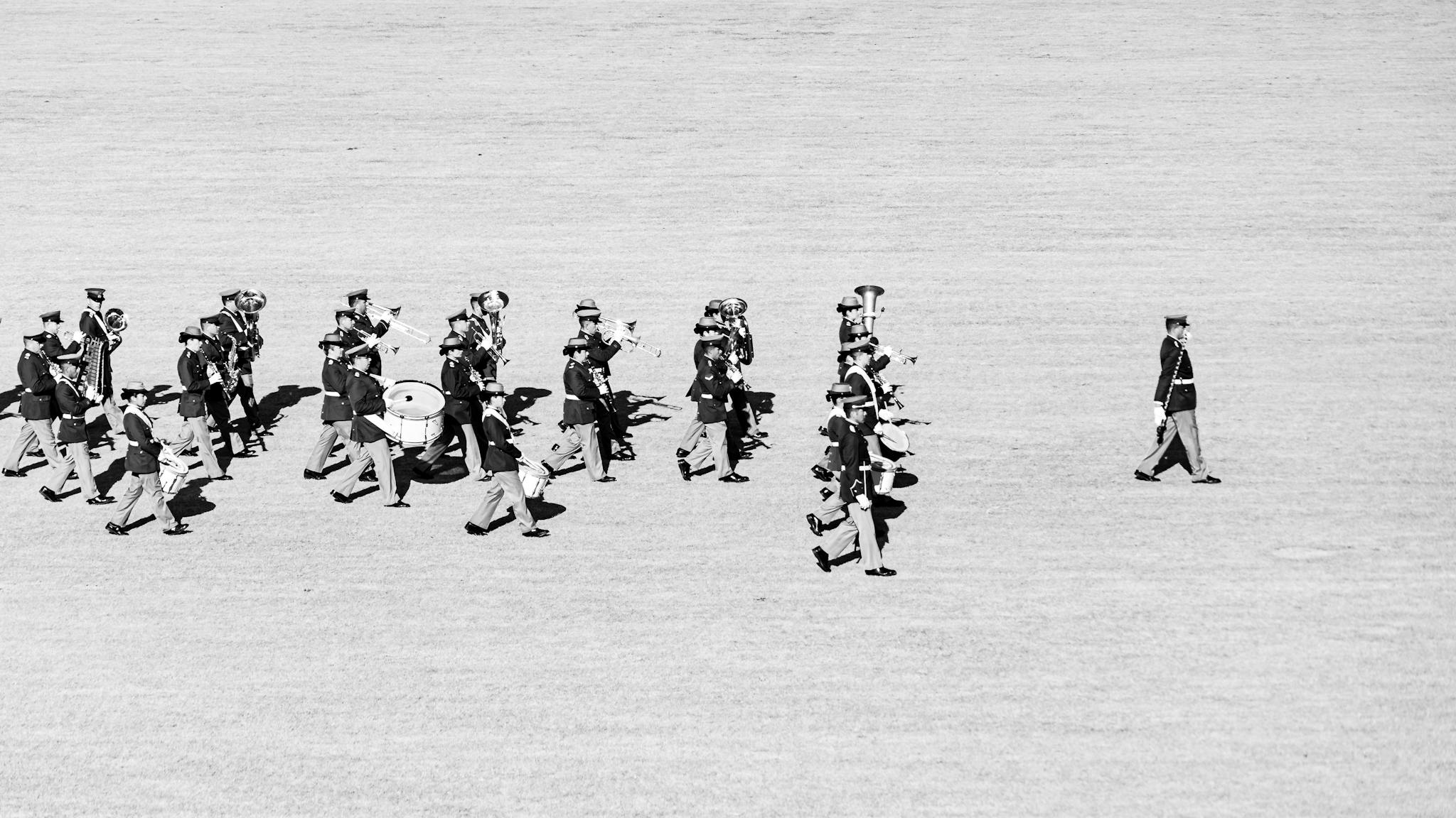 A black and white photo of a marching band in formation on a field